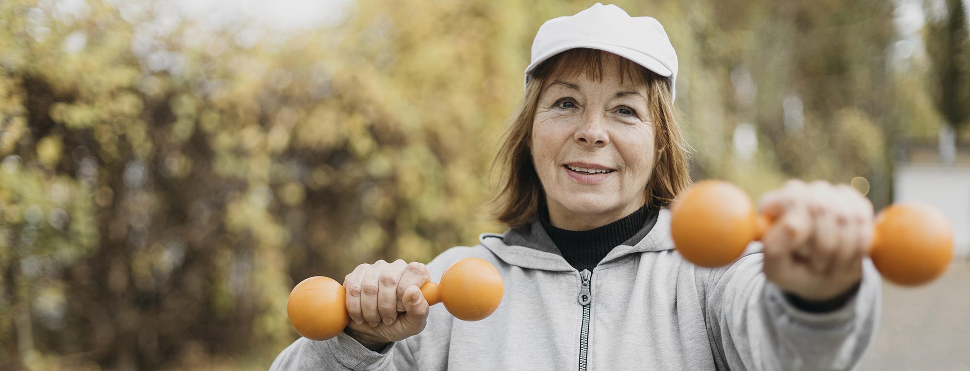 smiley elderly woman working out with weights